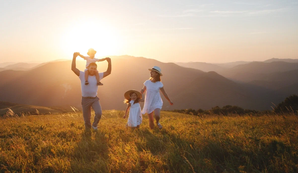 Bild von Familien bei Sonnenuntergang auf Wiese_Im Hintergrund Berge